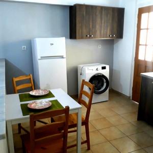 a kitchen with a table and a washing machine at InStyle Zakynthos town Apartment in Zakynthos Town