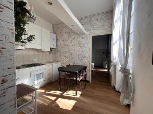 a kitchen with a table and a brick wall at Ancient Courtyard Bonanomi in Como Historic Centre in Como