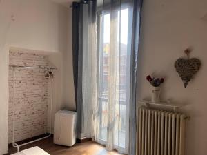 a room with a window with a radiator and a heart on the wall at Ancient Courtyard Bonanomi in Como Historic Centre in Como