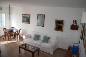 sala de estar con sofá blanco y mesa en Apartamento en acantilado con wifi y aire acondicionado, en Sitges