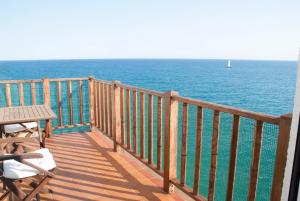 balcón con mesa, sillas y vistas al océano en Apartamento en acantilado con wifi y aire acondicionado, en Sitges