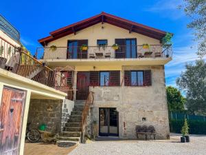 een huis met een balkon en een trap ervoor bij Casa da Pausa in Vila Verde