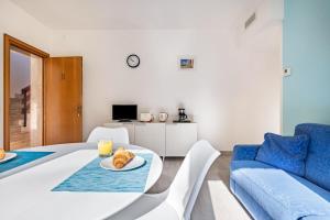 a living room with a white table and a blue couch at Casa Milani Malcesine apt 2 in Malcesine
