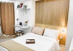 1 dormitorio con cama, escritorio y mesa en Largest 2-Bed Studio in Azure North, Pampanga en San Fernando