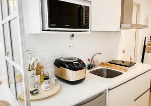 eine Küchentheke mit einem Toaster und einer Spüle in der Unterkunft Largest 2-Bed Studio in Azure North, Pampanga in San Fernando