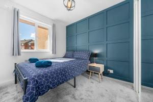 a blue bedroom with a bed and a window at I'm Your Host - Bridgeton House in Glasgow