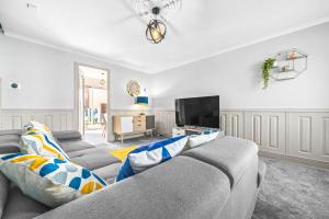 a living room with a couch and a flat screen tv at I'm Your Host - Bridgeton House in Glasgow