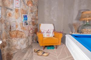 a living room with a chair and a table at Casa da Pausa by TonsdeVerde in Vila Verde