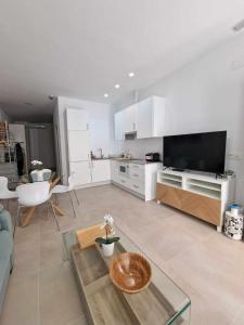a living room with a couch and a tv and a table at Urban suite 1 in Málaga