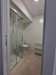 a bathroom with a toilet and a glass shower at Urban suite 1 in Málaga +9 photos