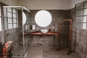 a bathroom with a shower with a sink and a mirror at El Rincón. Farm and Lodge in Carmelo