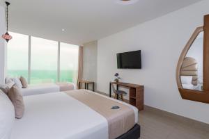 Habitación de hotel con 2 camas y TV de pantalla plana. en Hotel Cartagena Dubai en Cartagena de Indias