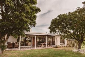 a home with a porch with trees in the yard at El Rincón. Farm and Lodge in Carmelo