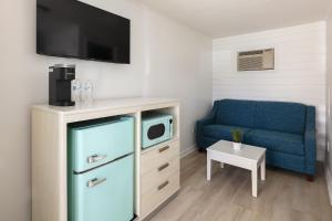 ein Wohnzimmer mit einem Kühlschrank und einem blauen Sofa in der Unterkunft Lily & Bloom in Myrtle Beach