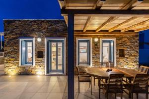 a dining room with a wooden table and chairs at Villa Fani Kythnos in Kithnos