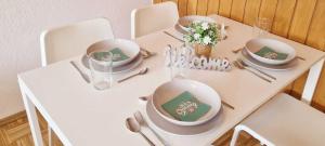 una mesa blanca con sillas, cuencos y platos en ella en Apartment in Hanau en Hanau am Main