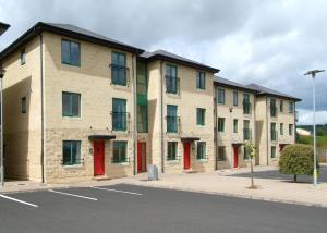 a row of buildings with red doors on a street at Ballyraine Self Catering in Letterkenny