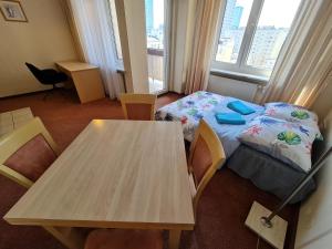 een kleine kamer met een tafel, een bed en een raam bij 10Q - Z6 Apartament 904 in Warschau