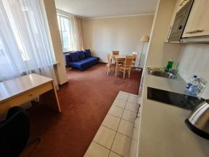 een keuken en een woonkamer met een blauwe bank en een tafel bij 10Q - Z6 Apartament 904 in Warschau