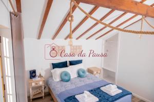 een slaapkamer met een blauw bed met een bord aan de muur bij Casa da Pausa in Vila Verde
