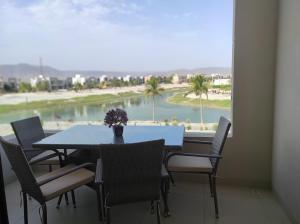 a table and chairs with a view of a beach at Star Hawana Salalah Forest Island in Salalah