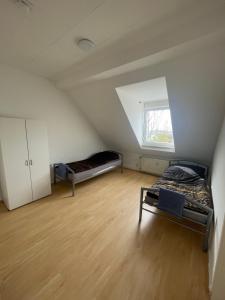 4 Zimmer Bruchsal City Monteurzimmer Küche/Bad في بروشسال: غرفة علوية بسريرين ونافذة