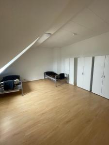 Habitación vacía con sofá y suelo de madera. en 4 Zimmer Bruchsal City Monteurzimmer Küche/Bad, en Bruchsal