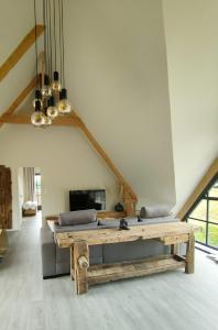 un salon avec un canapé et une table en bois dans l'établissement Les Délices de la Vie, à Le Mesnil-Germain