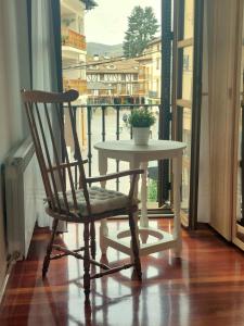 a chair and a table with a plant on a balcony at Apartamento céntrico en Ezcaray in Ezcaray