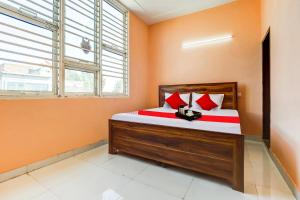 ein Schlafzimmer mit einem Bett mit orangefarbenen Wänden und einem Fenster in der Unterkunft OYO Hotel Swagat in Zirakpur