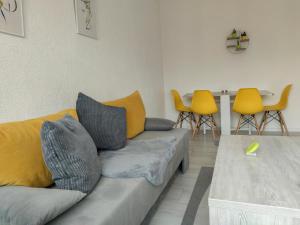 - un salon avec un canapé et des fauteuils jaunes dans l'établissement Central Modern Apartment Sarajevo, à Sarajevo