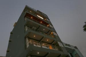 un edificio de apartamentos alto con luces encendidas en Townhouse Zodiac Near Botanic Garden of Indian Republic, en Noida