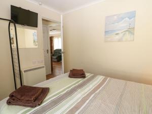 a bedroom with a bed with two towels on it at Willow Lodge in Liskeard