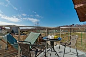 a patio with a table and chairs on a deck at HORN Jastarnia in Jastarnia