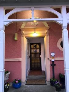 a front door of a pink building with a sign on it at Glentower Lower Observatory in Fort William