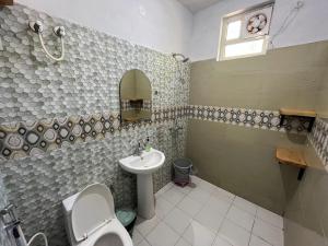 a bathroom with a toilet and a sink at THG - The Hidden Garden Bir in Bīr