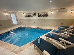 a large swimming pool with chairs and a swimming pool at Alina Boutique Living in Victoria