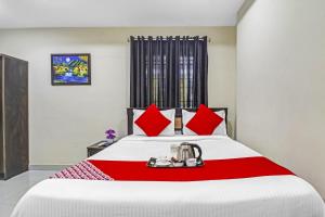 um quarto com uma cama grande e almofadas vermelhas em Super OYO Honey Heights Near Botanical Garden em Hyderabad