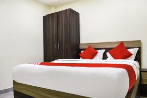 a bedroom with two beds with red pillows at Flagship S&h Residency in Khandagiri