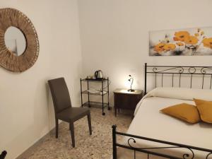 a bedroom with a bed and a chair and a mirror at B&B 24 Maggio in Carloforte
