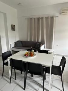 einen weißen Tisch und Stühle im Wohnzimmer in der Unterkunft Flampoura Apartments in Preveza