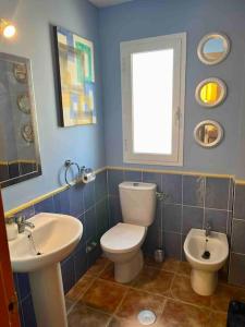 a bathroom with a white toilet and a sink at House sleeps 6, large pool walk to beach in Vera