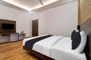 a bedroom with a bed and a flat screen tv at Townhouse OAK Armeria in Lucknow