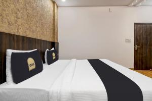 a bedroom with a bed with black and white pillows at Super Townhouse OAK Armeria in Lucknow +35 photos