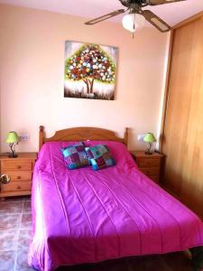 una camera con letto rosa e un albero di zuccheri di House sleeps 6, large pool walk to beach a Vera