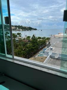 una ventana de un edificio con vistas al océano en Residencial Neli Passos, en Itapema