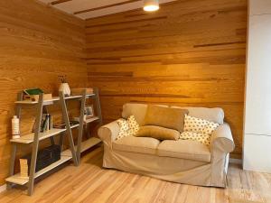 リュネヴィルにあるL'écolodge de Laetiのソファ付きのリビングルーム、木製の壁