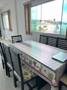 a table with chairs and a laptop on top of it at Residencial Neli Passos in Itapema