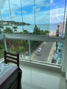 a bedroom with a view of a street and the ocean at Residencial Neli Passos in Itapema