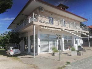 a house with a balcony and a car parked in front at KALIPSO STUDIOs in Nikiti +8 photos
